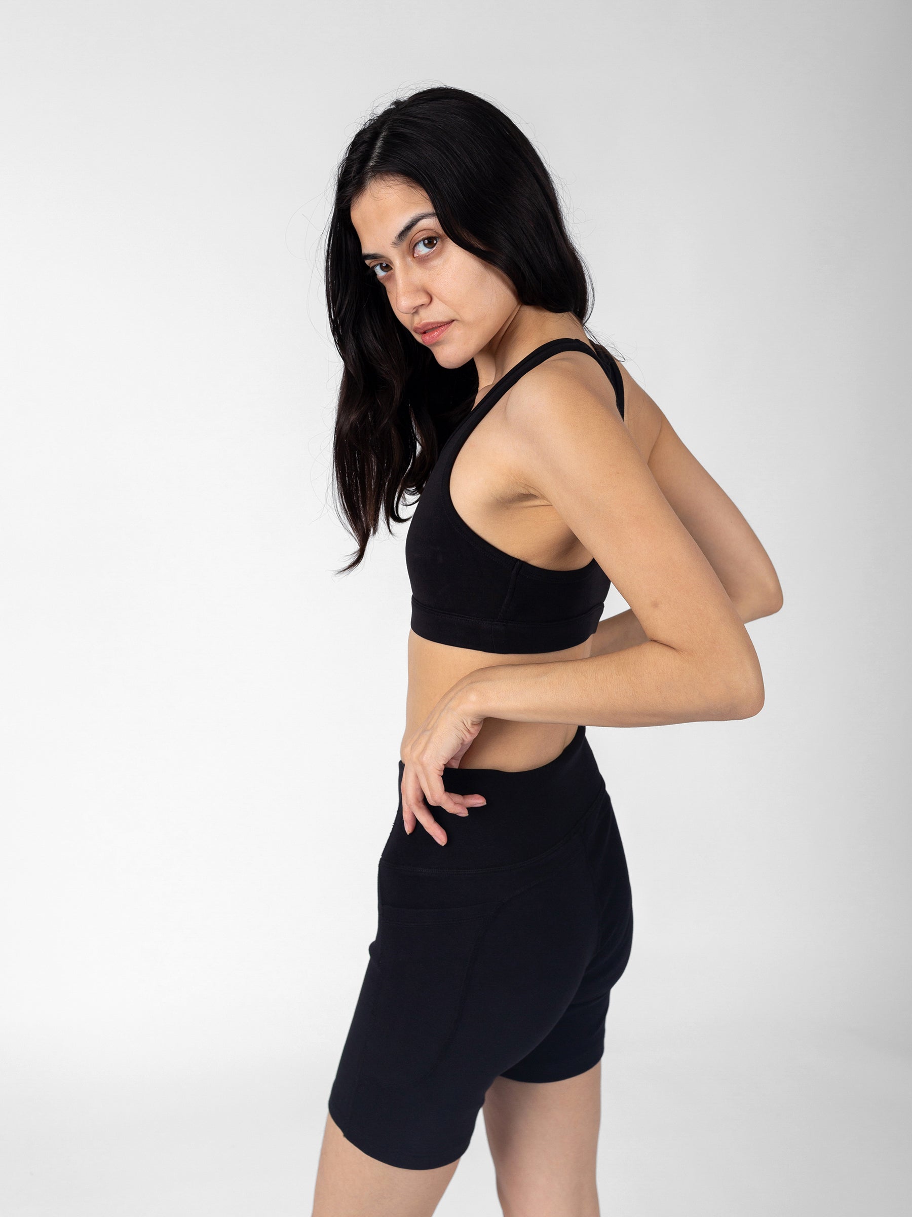 Side view, Eclipse black PlantTec sports bra, racerback straps visible, paired with bike shorts, non-toxic