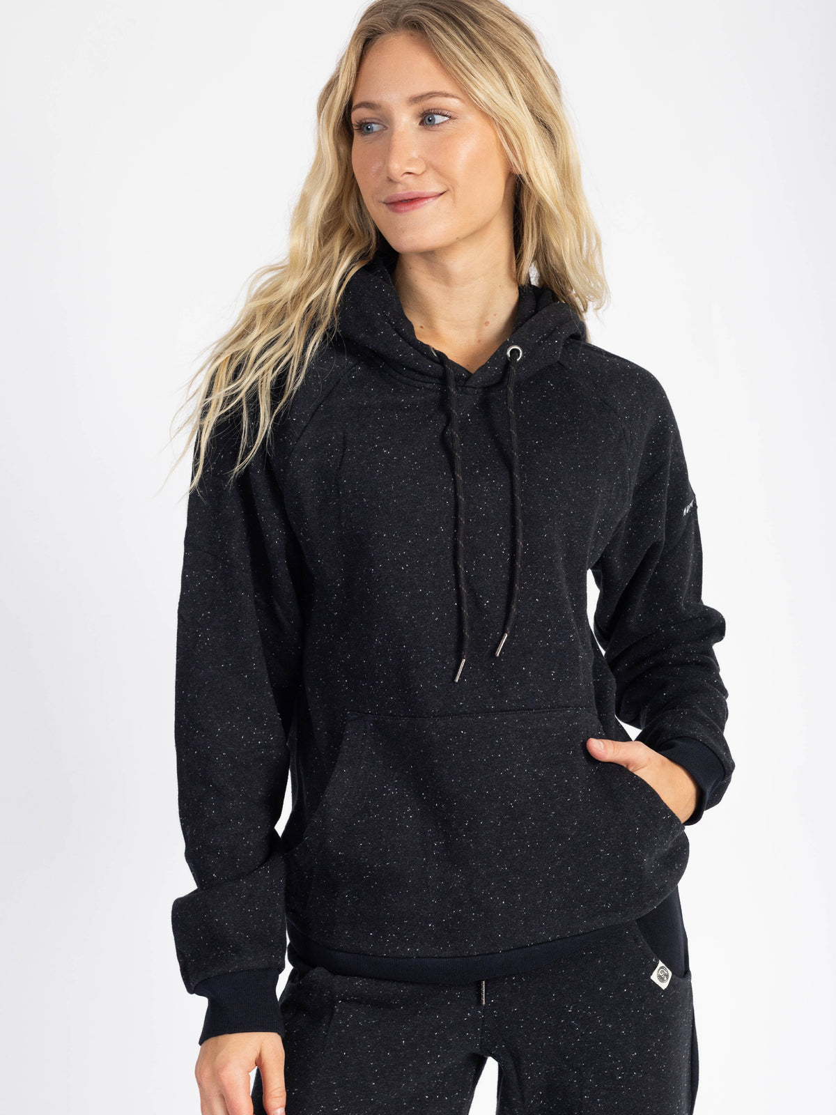 Model wearing the Eclipse black organic cotton hoodie, hand in pocket