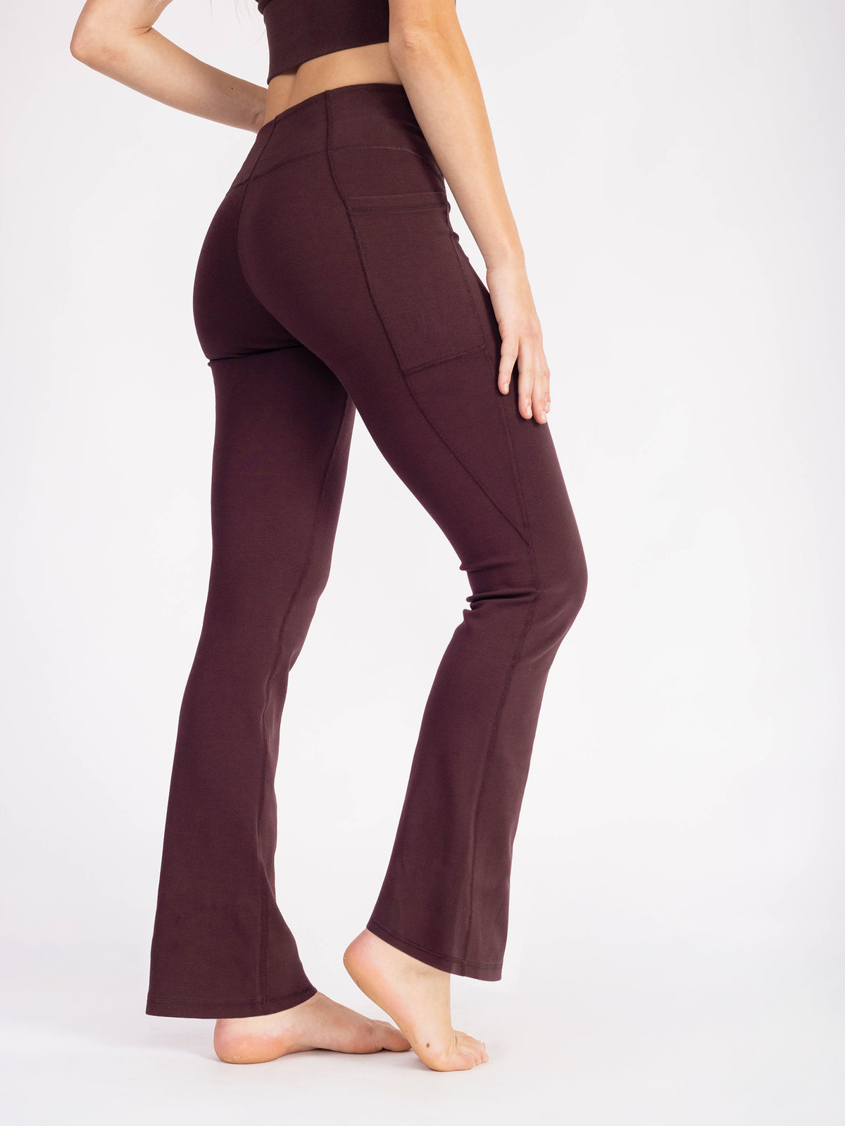 Waist-down three-quarter view of the Espresso brown PlantTec organic cotton flare leggings