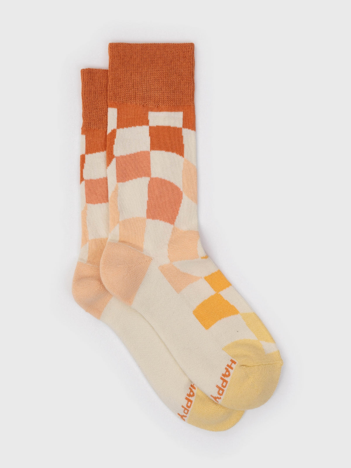 Flat lay of the Hopscotch organic cotton crew socks, wavy red, peach and yellow checkerboard
