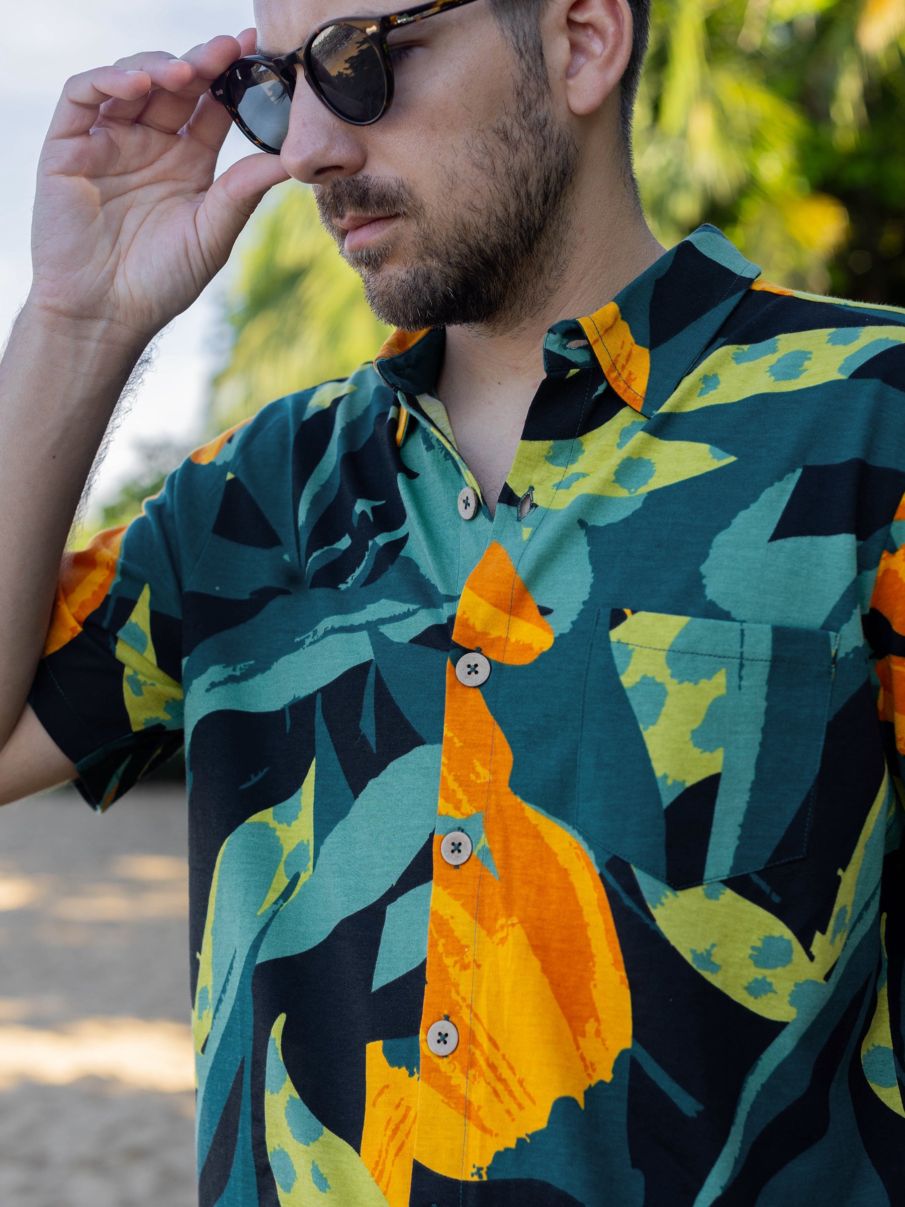 Men's Rincon Shirt in Hanalei print, featuring lush greens, bold golden blooms, and rosewood buttons.