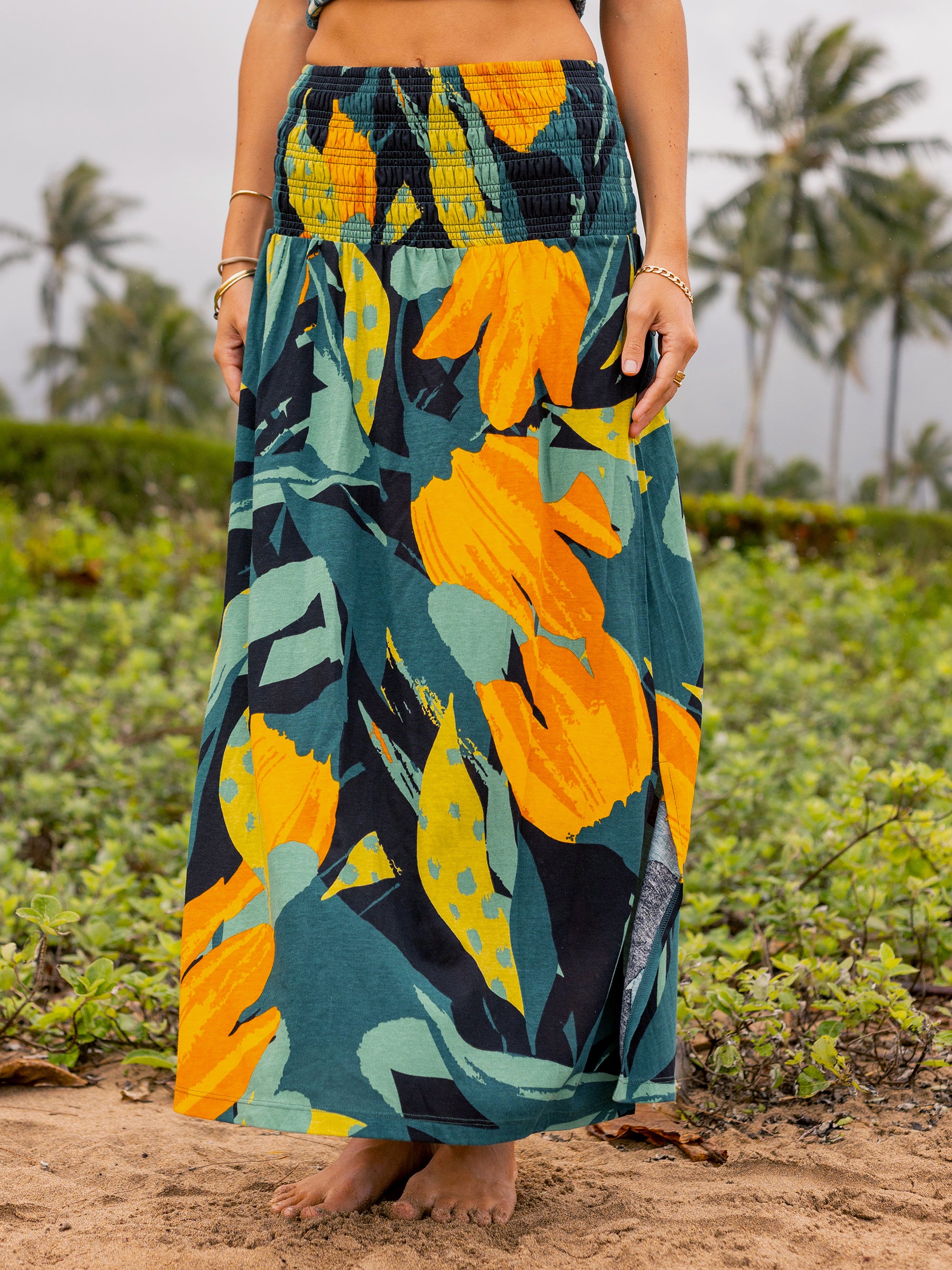 Hanalei Smocked Skirt: maxi length, organic cotton, green with bold golden floral print, wide smocked waistband.