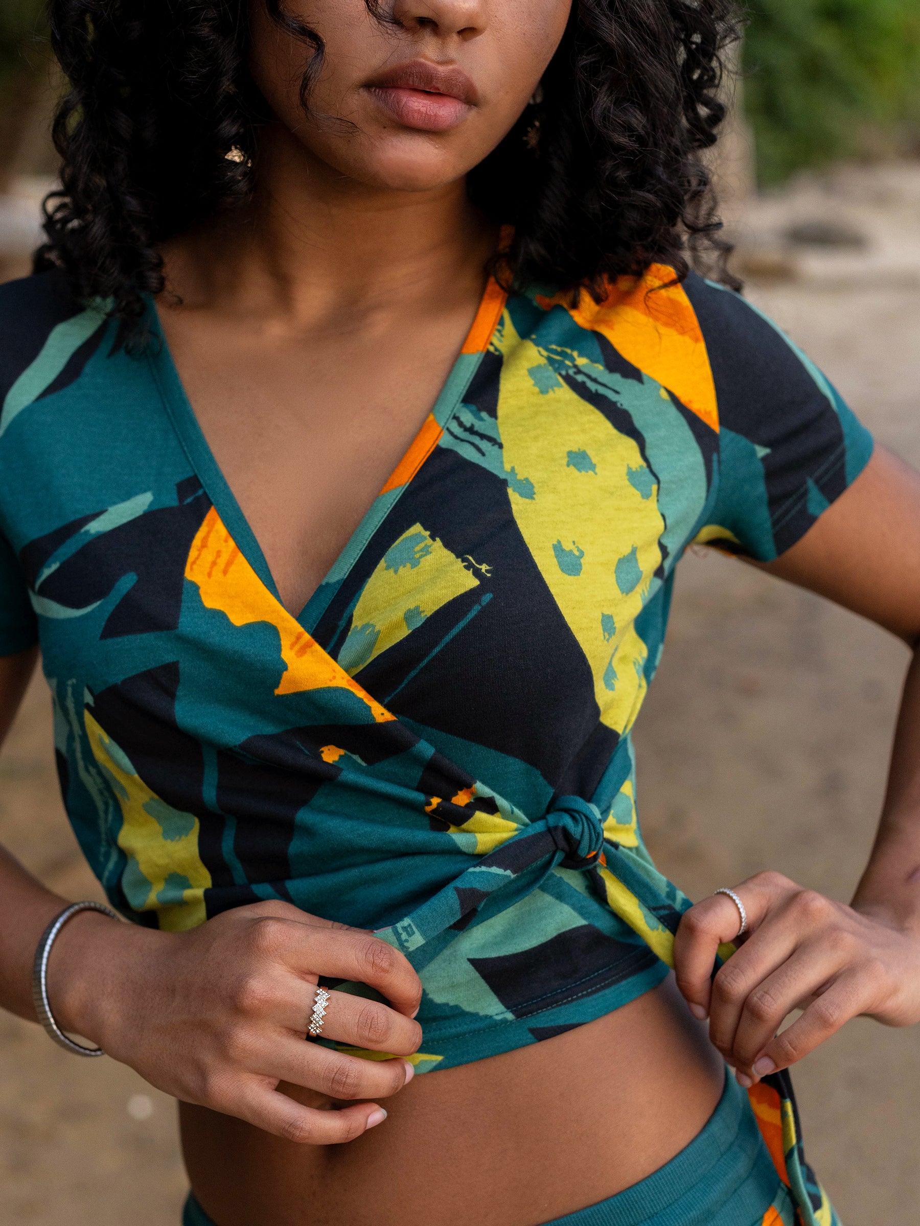 Hanalei Wrap Crop Top in organic cotton, featuring a vibrant green, yellow, and orange tropical print.