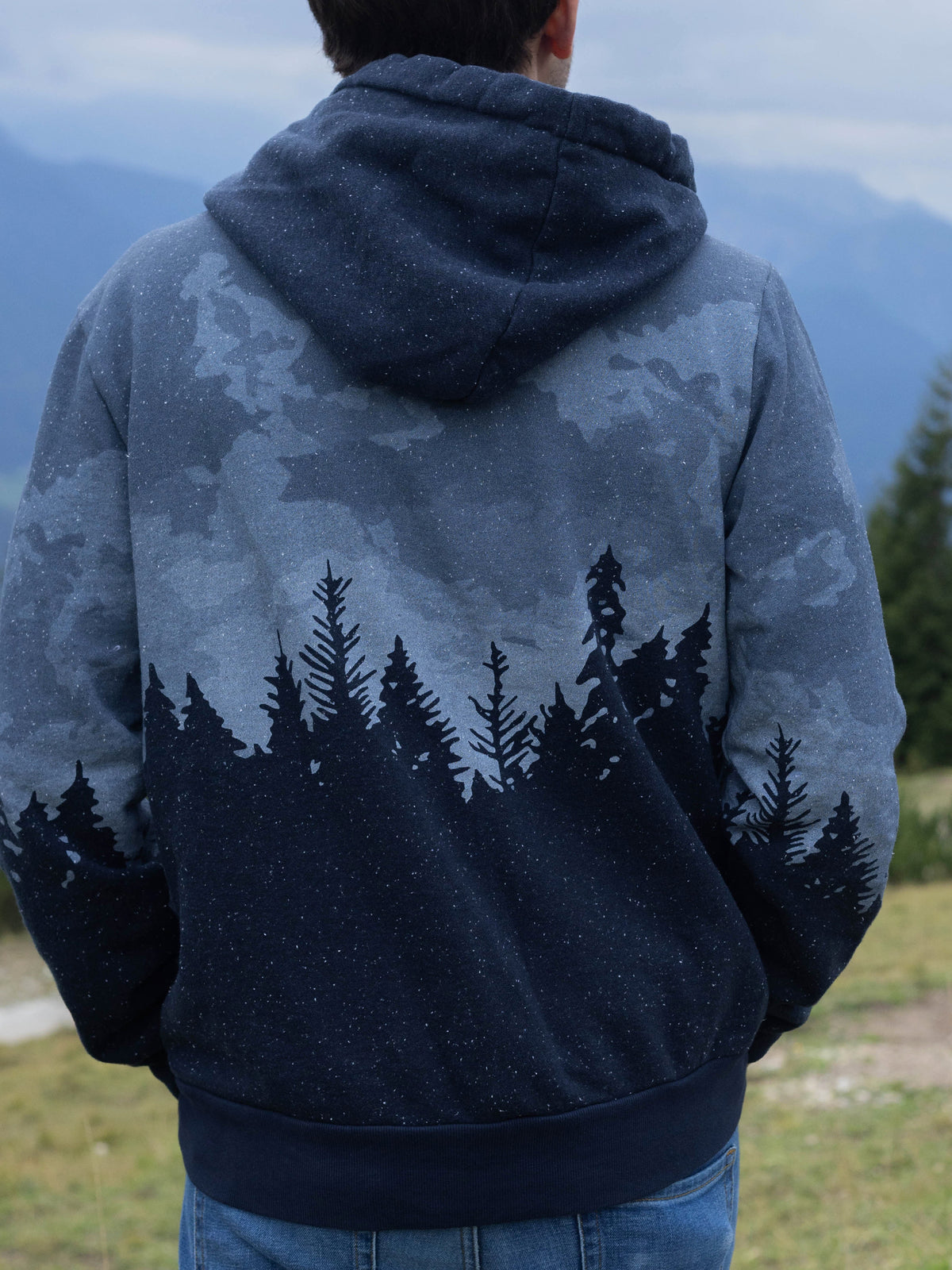 Back view of the Stardust organic cotton hoodie, pine forest across the back