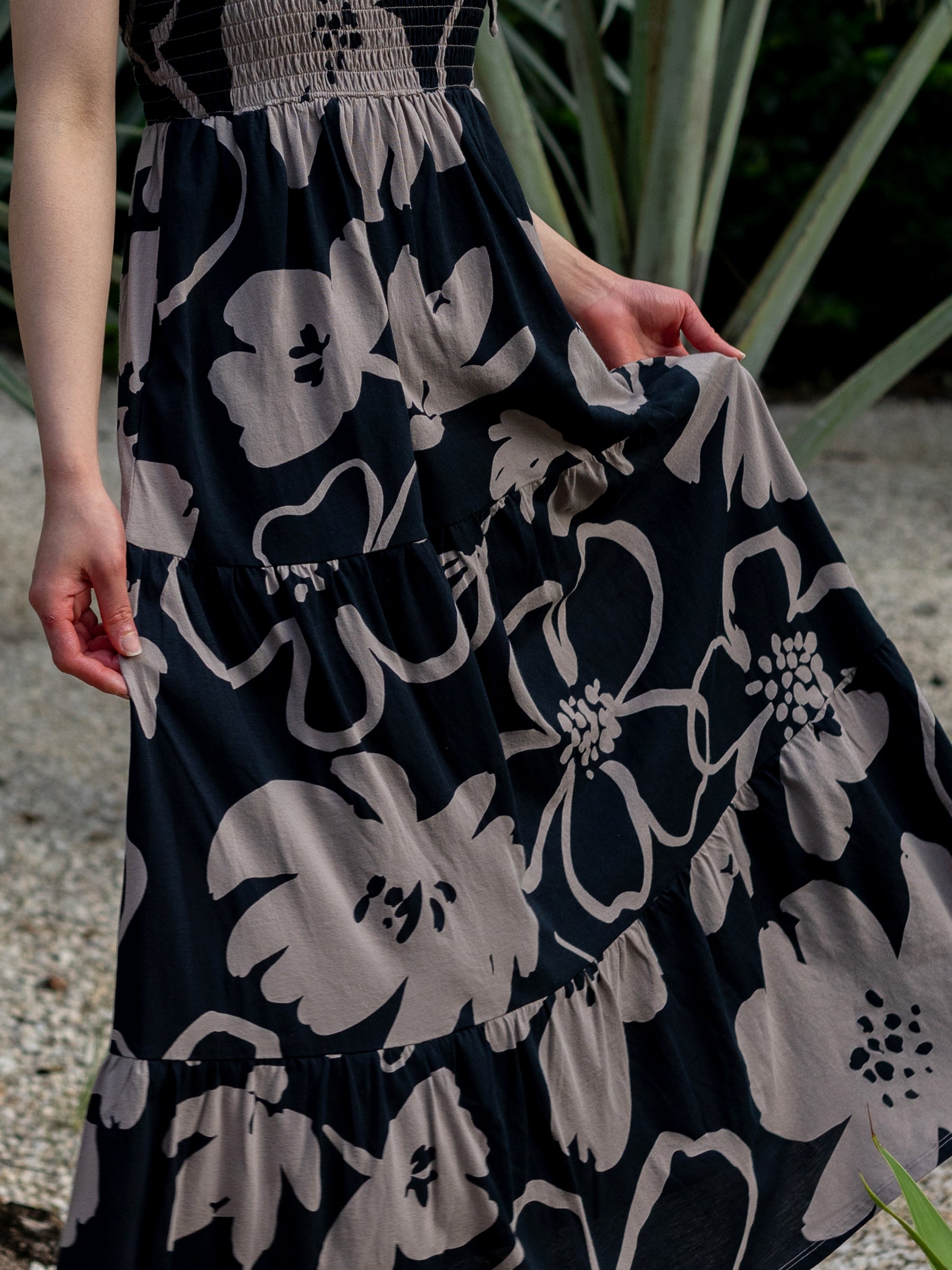Evie Smocked Dress in Moonflower: black organic cotton maxi with taupe floral print, smocked bodice, tiered skirt.