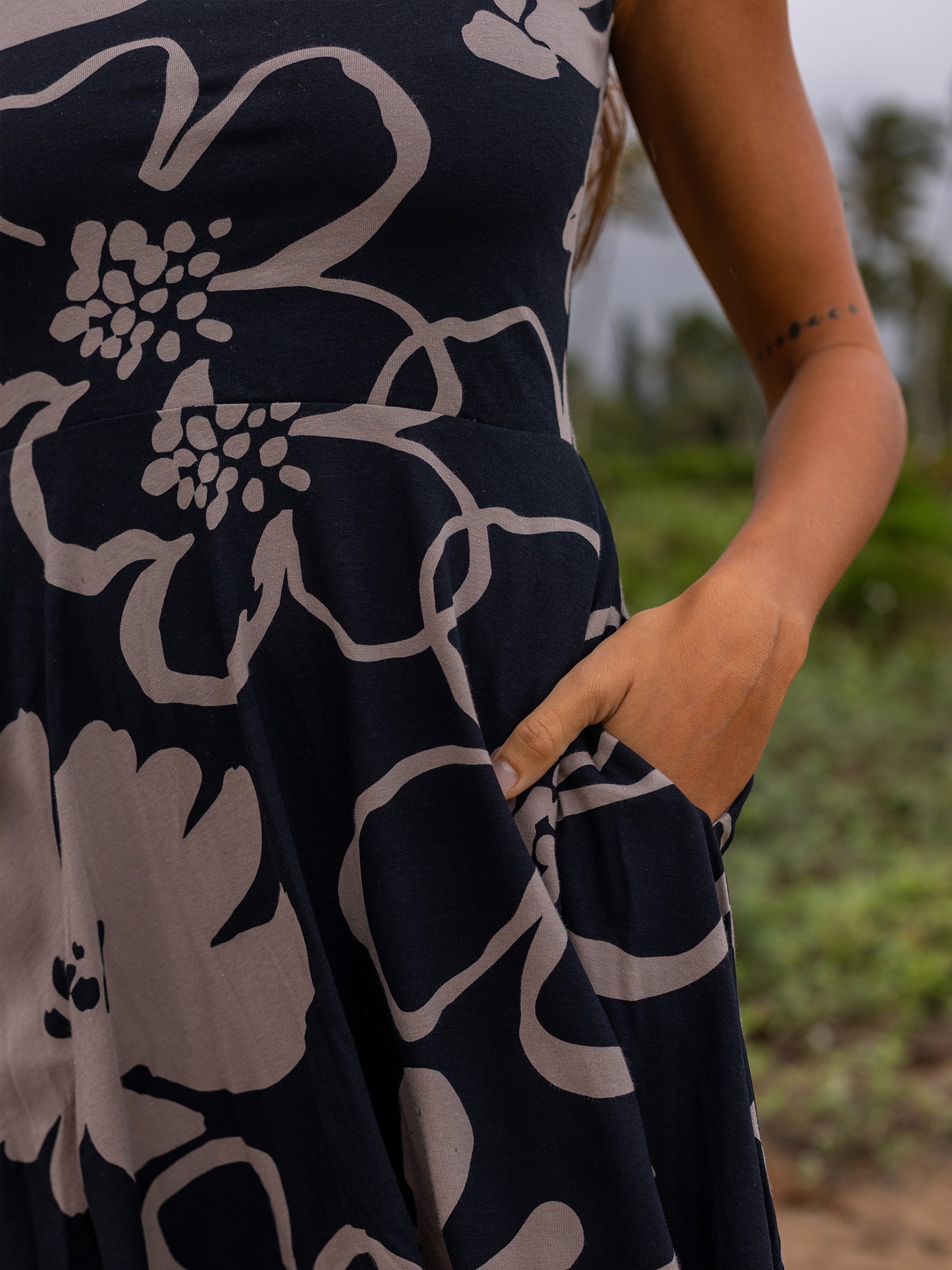 Lily Dress in Moonflower: close-up of dark floral print, hand in hidden pocket, organic cotton.