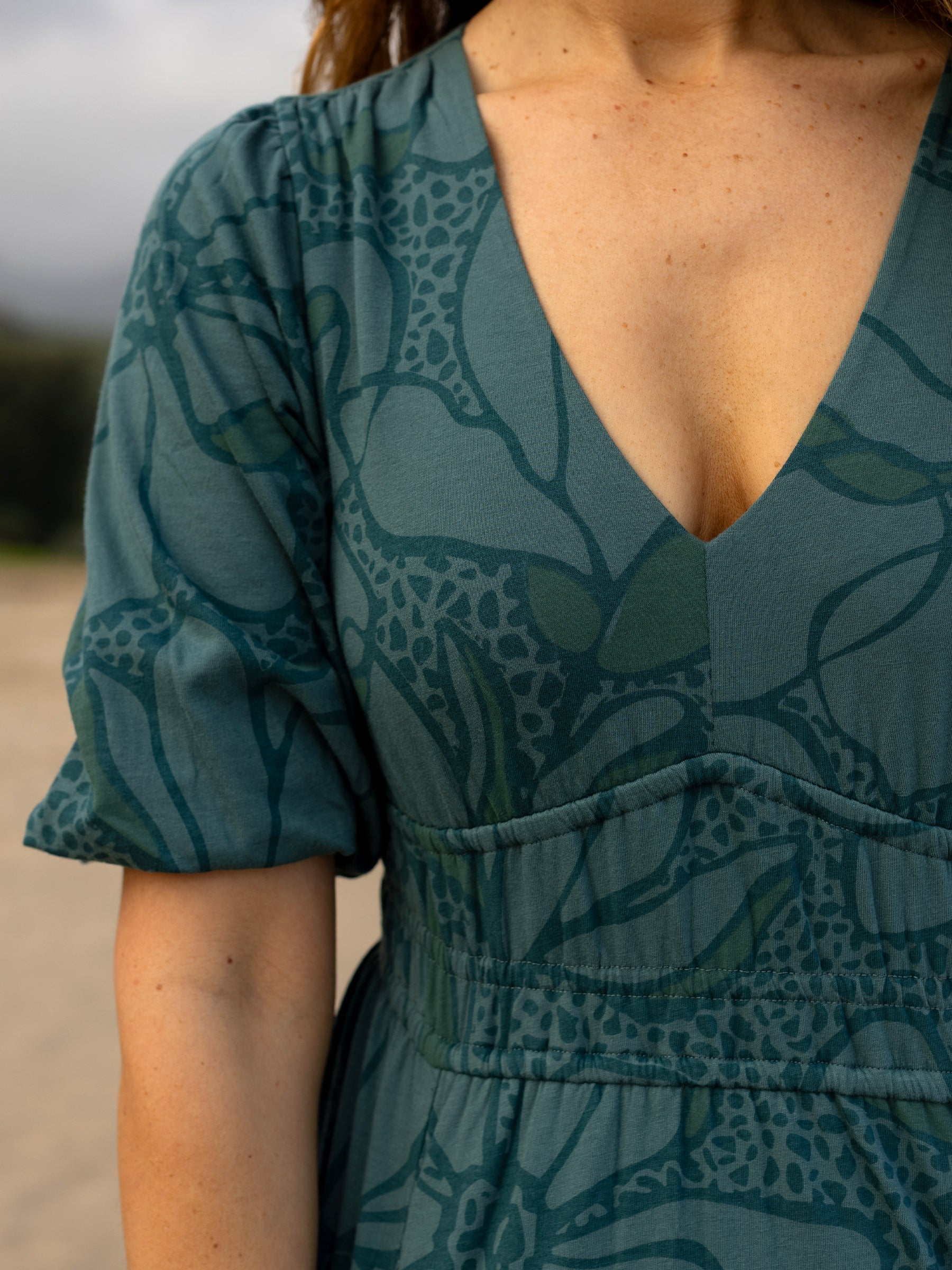 Ophelia Dress: Seaside teal organic cotton midi dress with large floral print, V-neck, puffed sleeves, and smocked waist.