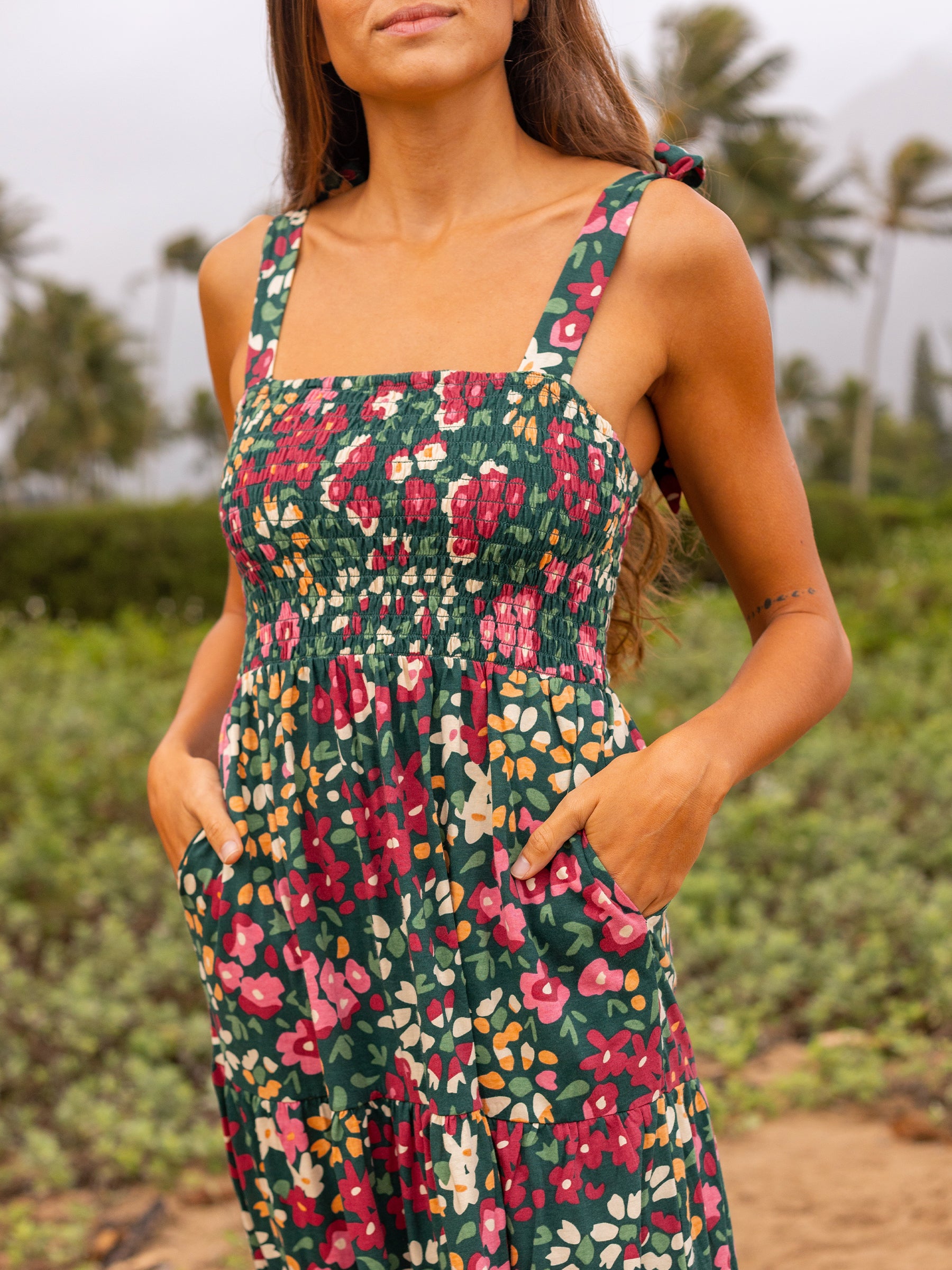Evie Smocked Dress in organic cotton with a green wildflower print, smocked bodice, and adjustable ribbon ties.