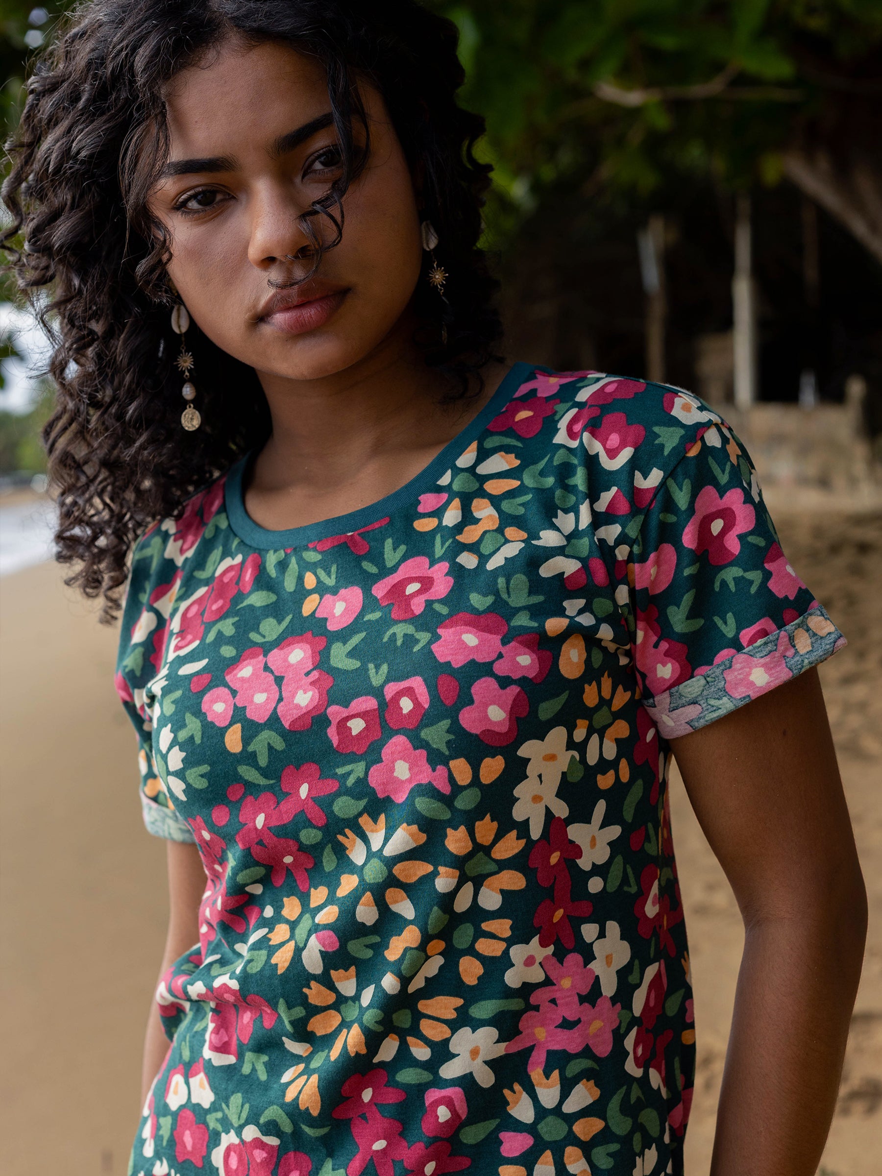 Woman in a green organic cotton Finley Dress with pink, orange, and white wildflower print, cuffed sleeves.
