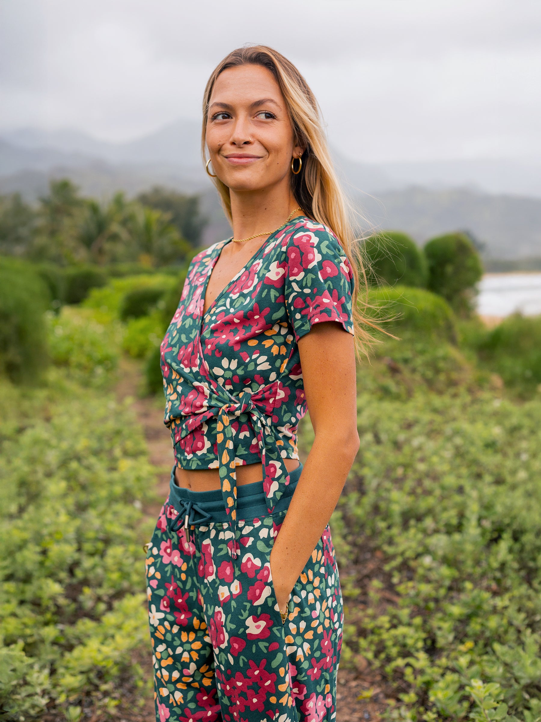 Woman in a green organic cotton wrap crop top with red and yellow wildflower print.