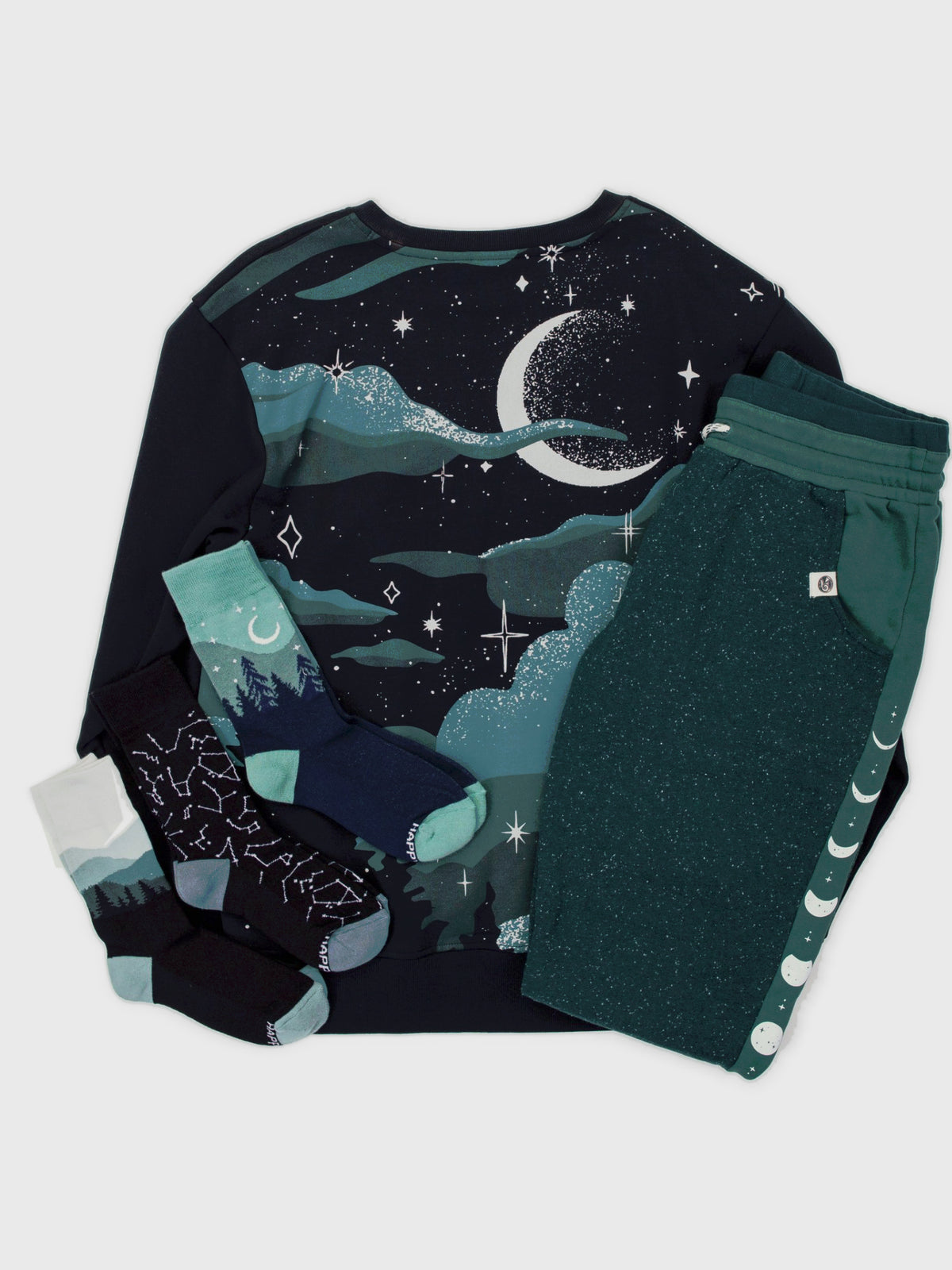 Nocturne Pullover Bundle flat lay: Nocturne organic cotton pullover, Lunar Glow joggers, and Constellations, Aurora and Smoky Mountains socks