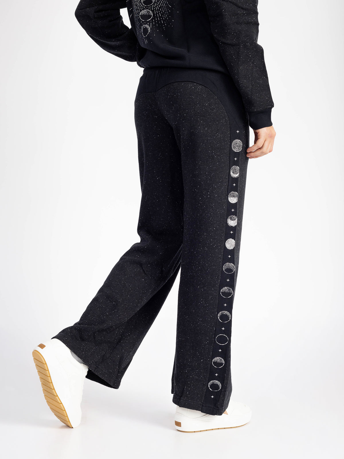 Model walking in the Dark Side organic cotton wide leg sweatpants, moon phase stripe