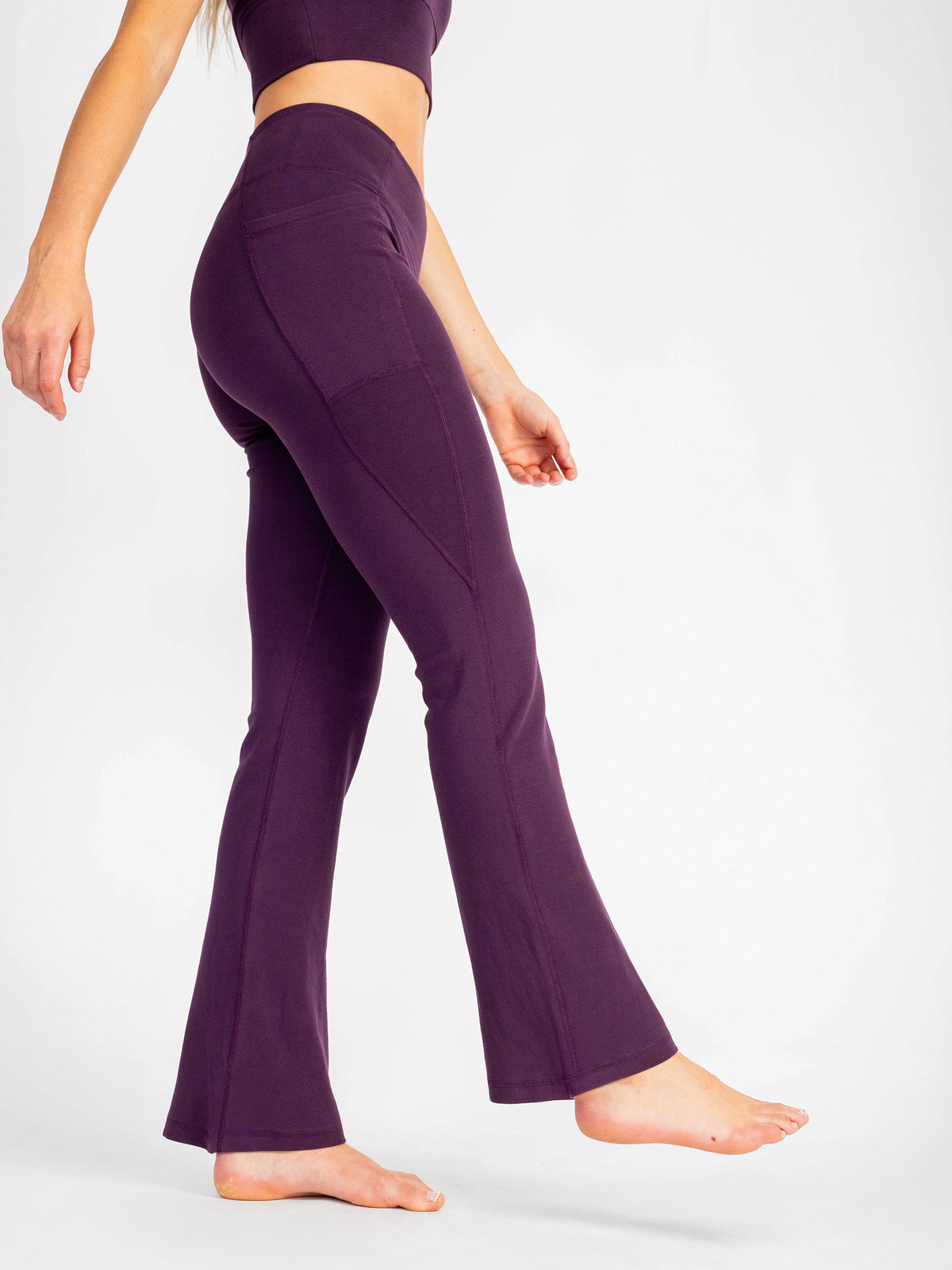 Side view of the Fig purple PlantTec organic cotton flare leggings, waist to flared hem