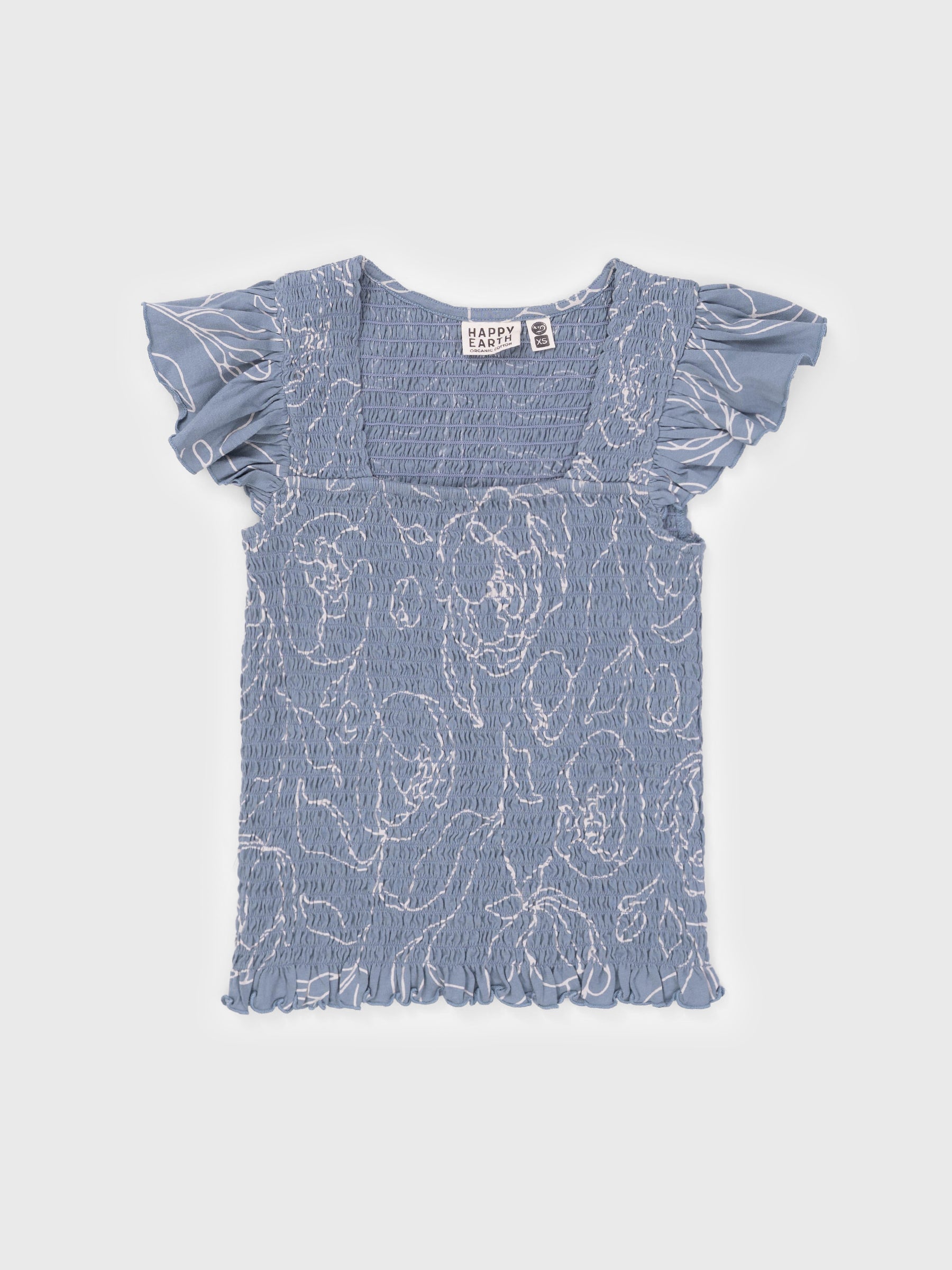 Smocked blue organic cotton top with white hand-drawn garden roses, square neckline, flutter cap sleeves, and ruffled hem.