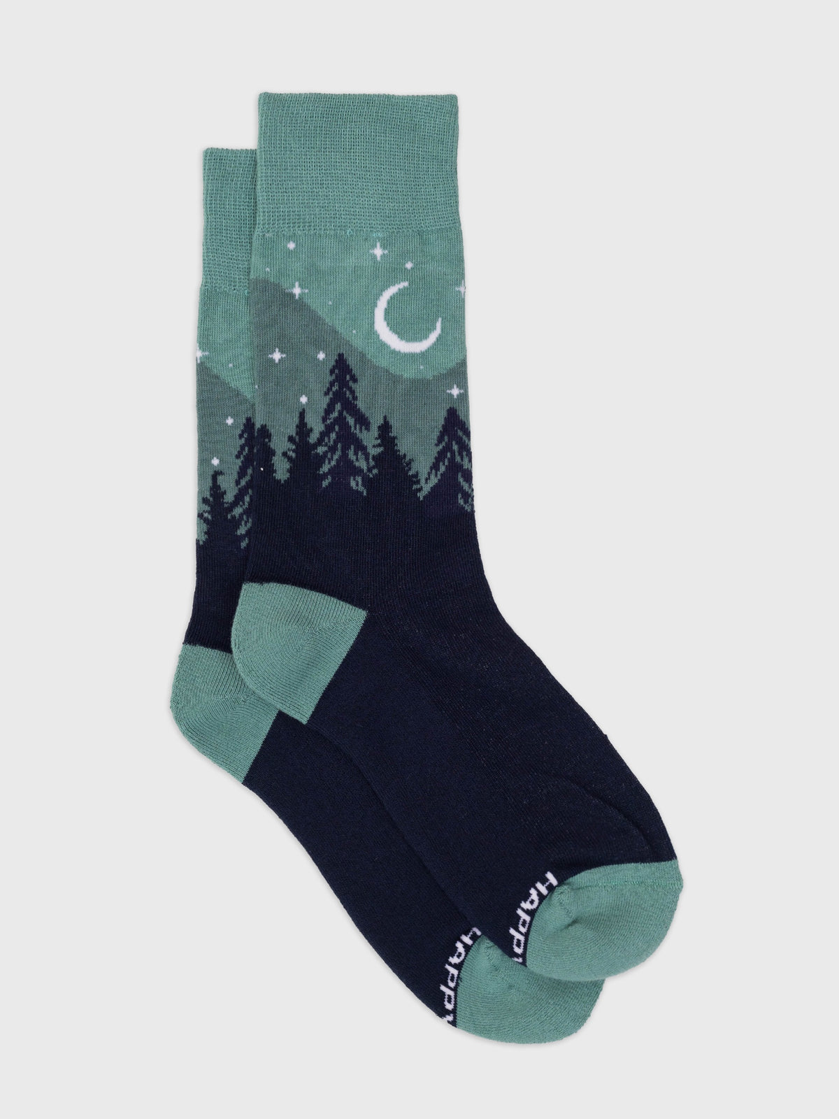 Flat lay of the Aurora organic cotton crew socks, teal sky with crescent moon over a navy pine forest