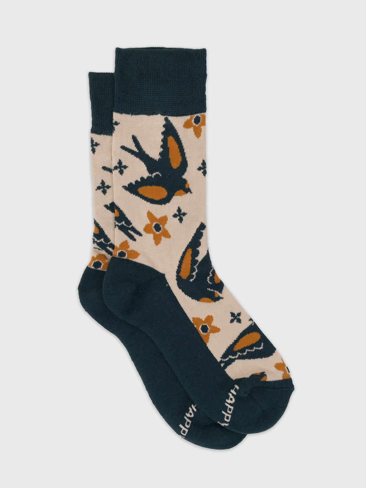 Flat lay of the Hygge organic cotton crew socks, Nordic folk birds and flowers on cream with deep teal foot