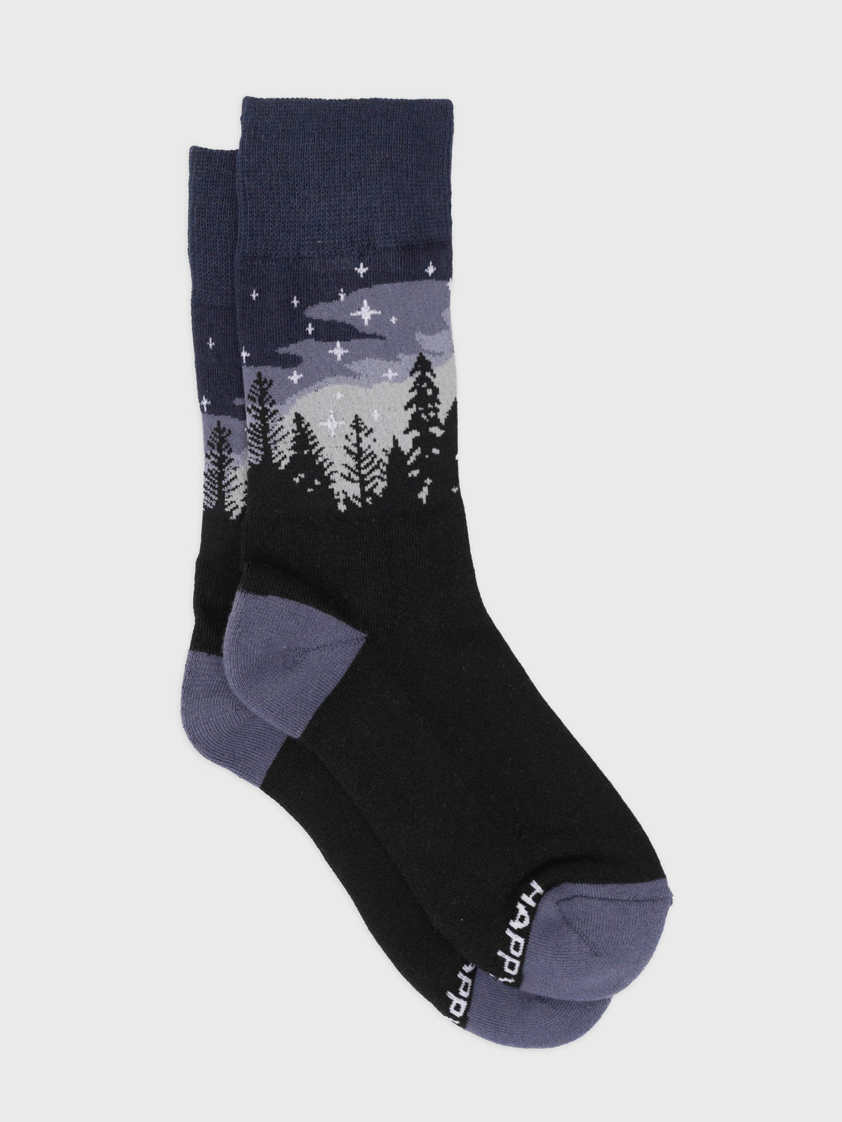 Flat lay of the Starlit Night organic cotton crew socks, starry navy sky over a pine forest with purple heel and toe