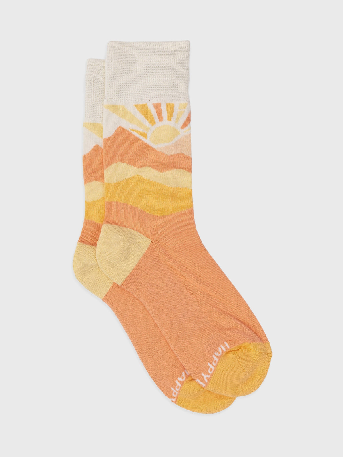 Flat lay of the Sunburst organic cotton crew socks, pastel peach and yellow sunrise with yellow heel and toe