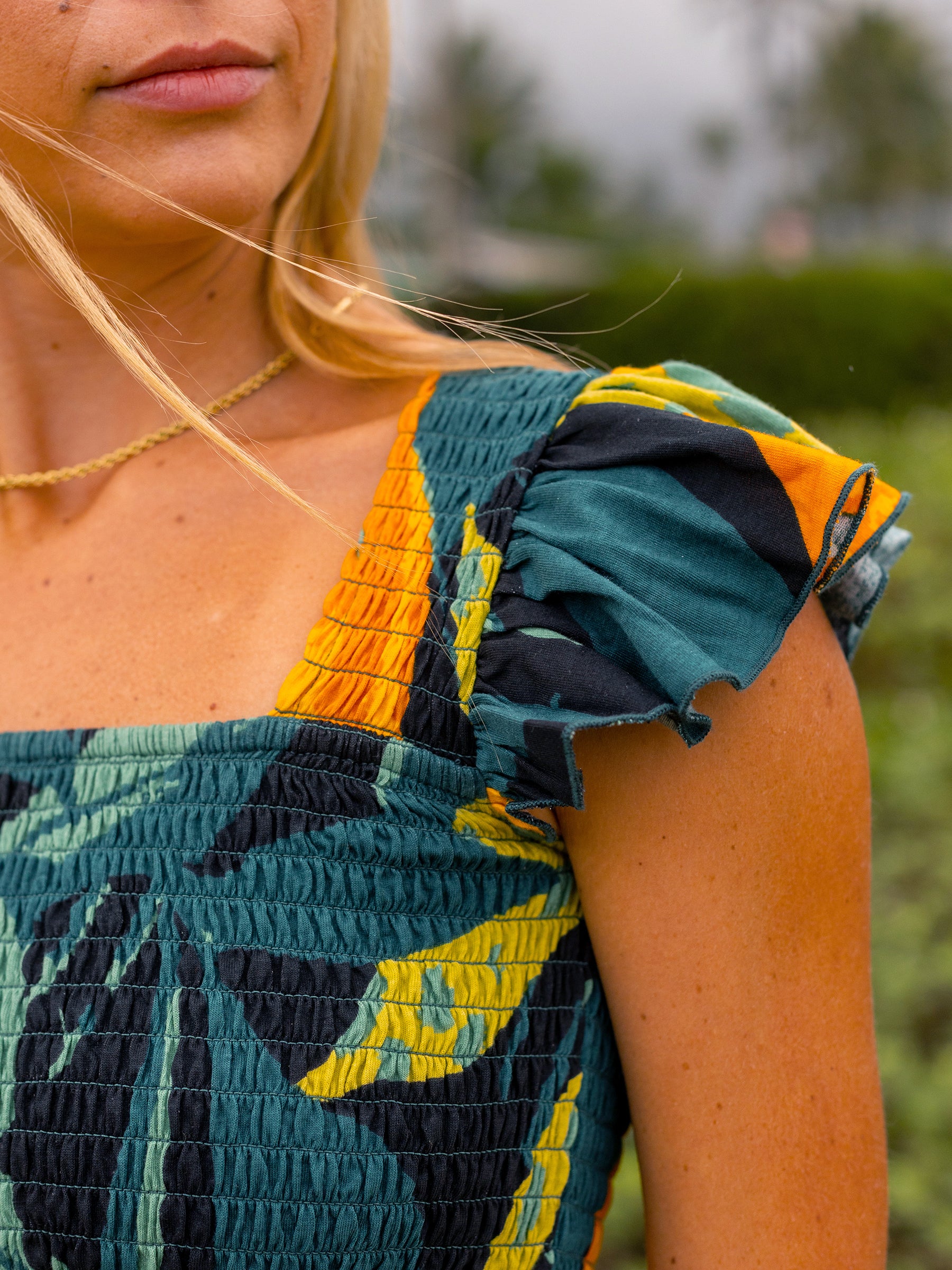 Smocked Hanalei top in organic cotton, featuring a square neckline, flutter cap sleeves, and tropical print.