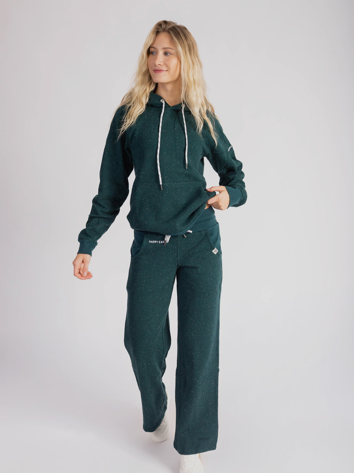 Model wearing the Monstera teal organic cotton hoodie with matching wide leg sweatpants, full length
