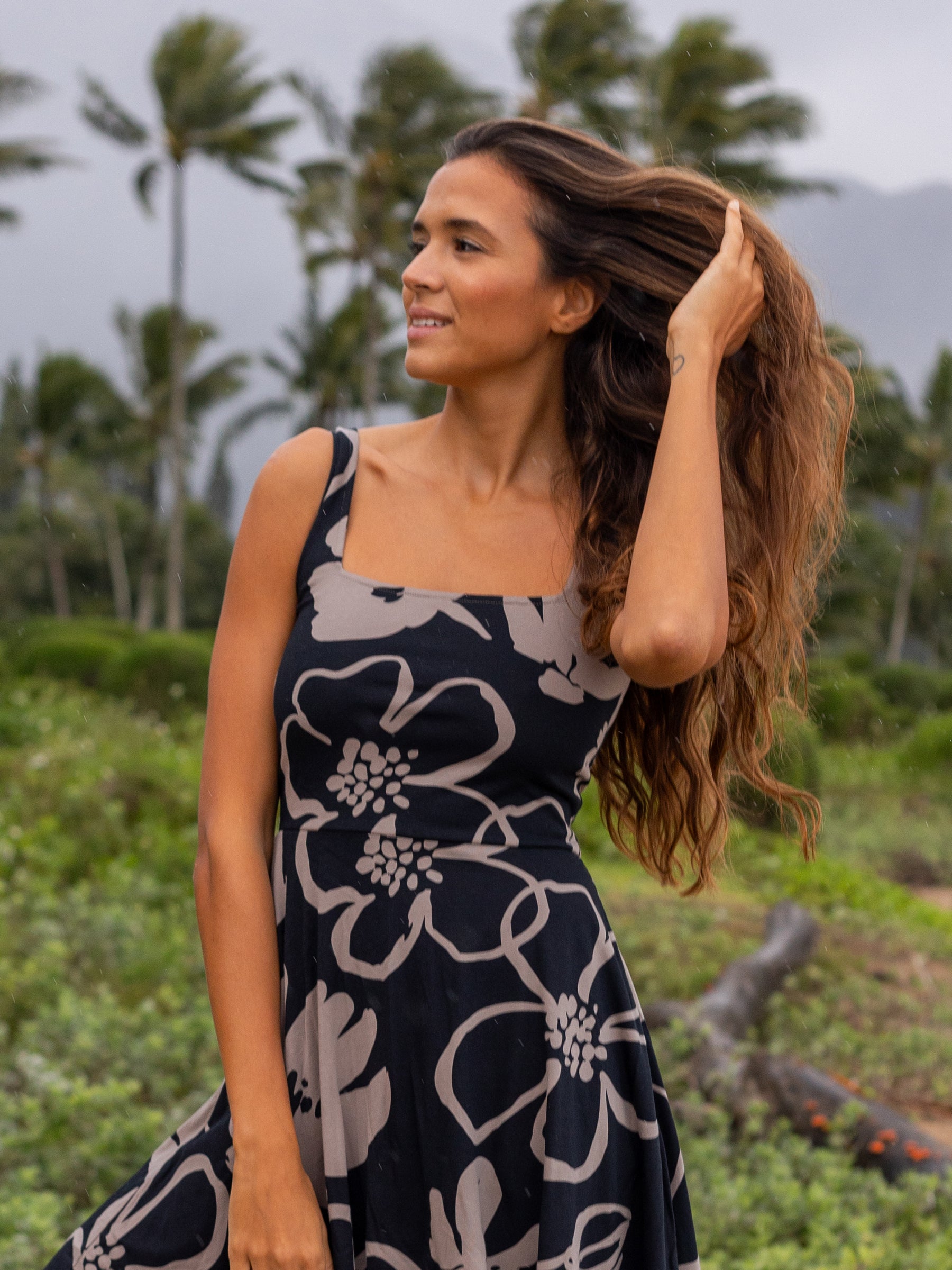 Woman in a black Lily Dress with taupe moonflower print, square neckline, and wide straps.