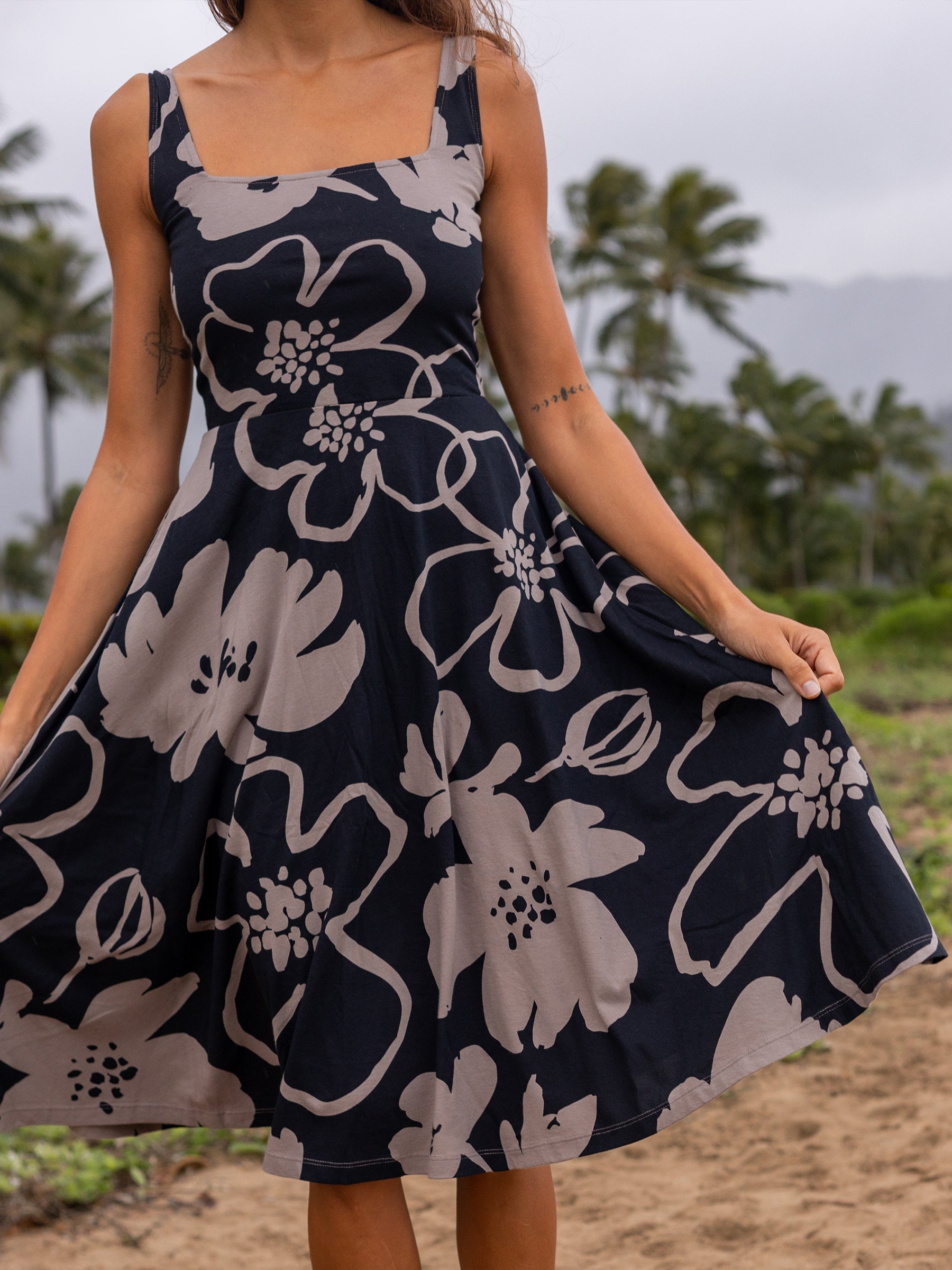 Moonflower Lily Dress: Black organic cotton midi dress with large taupe floral print, square neckline, and wide straps.