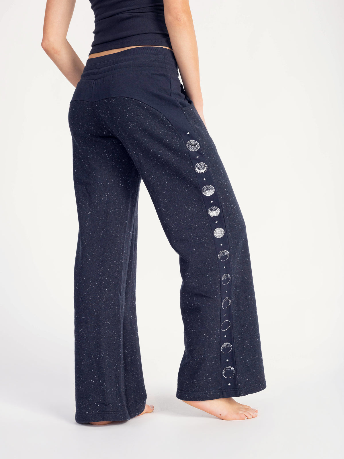 Back view of the navy Moonshine organic cotton wide leg sweatpants with moon phase stripe, barefoot
