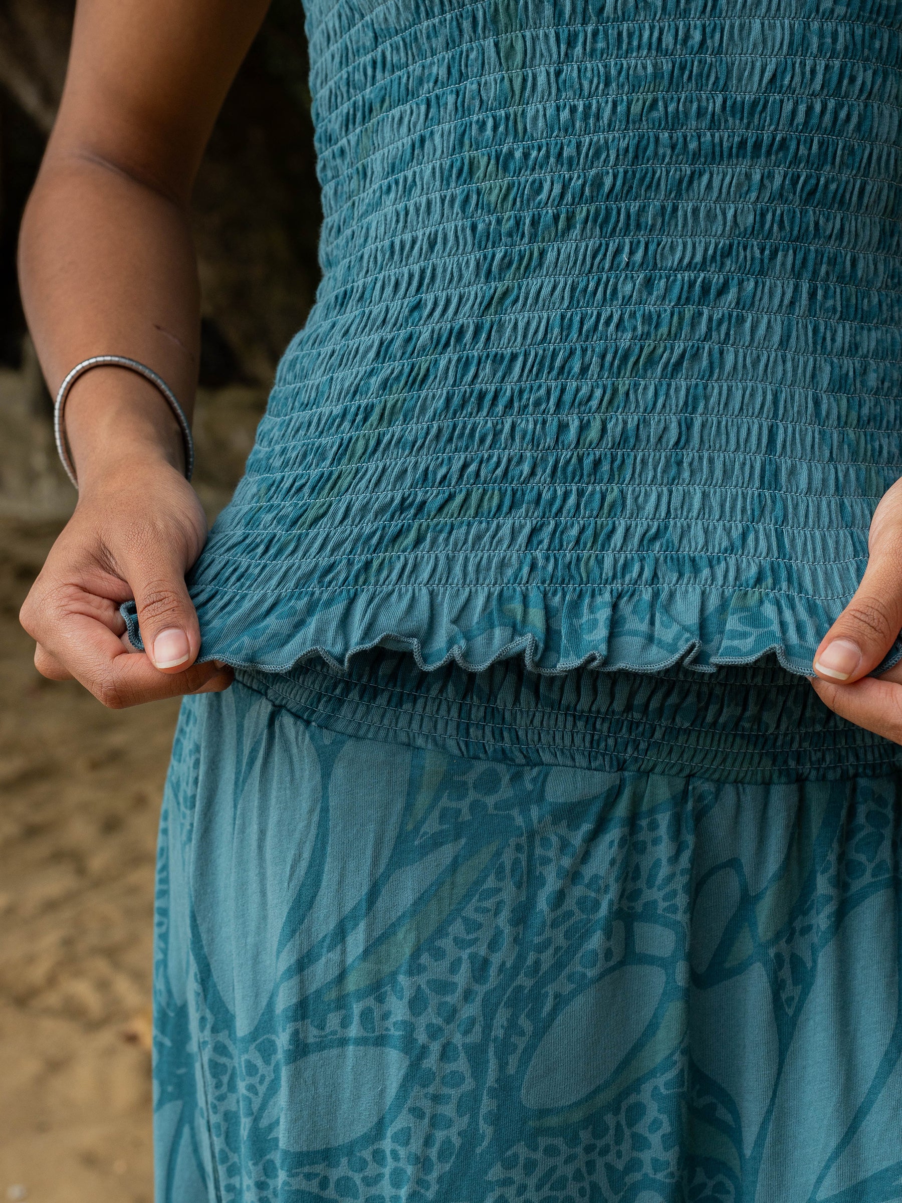 Teal organic cotton smocked top with ruffled hem, paired with matching floral print pants.
