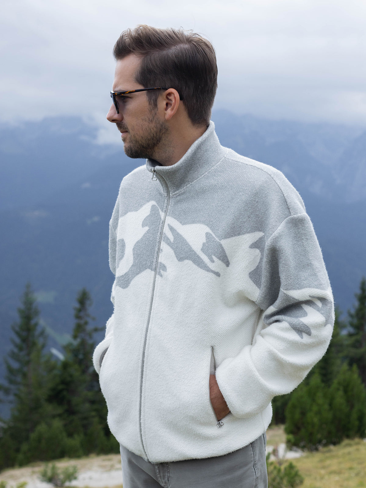 Model in sunglasses wearing the white Altitude organic cotton sherpa jacket, hands in pockets