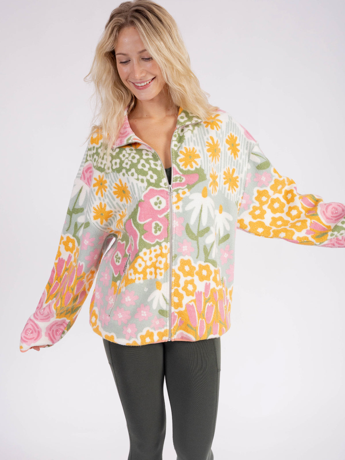 Model wearing the floral Bouquet organic cotton sherpa jacket, arm out to show the sleeve print