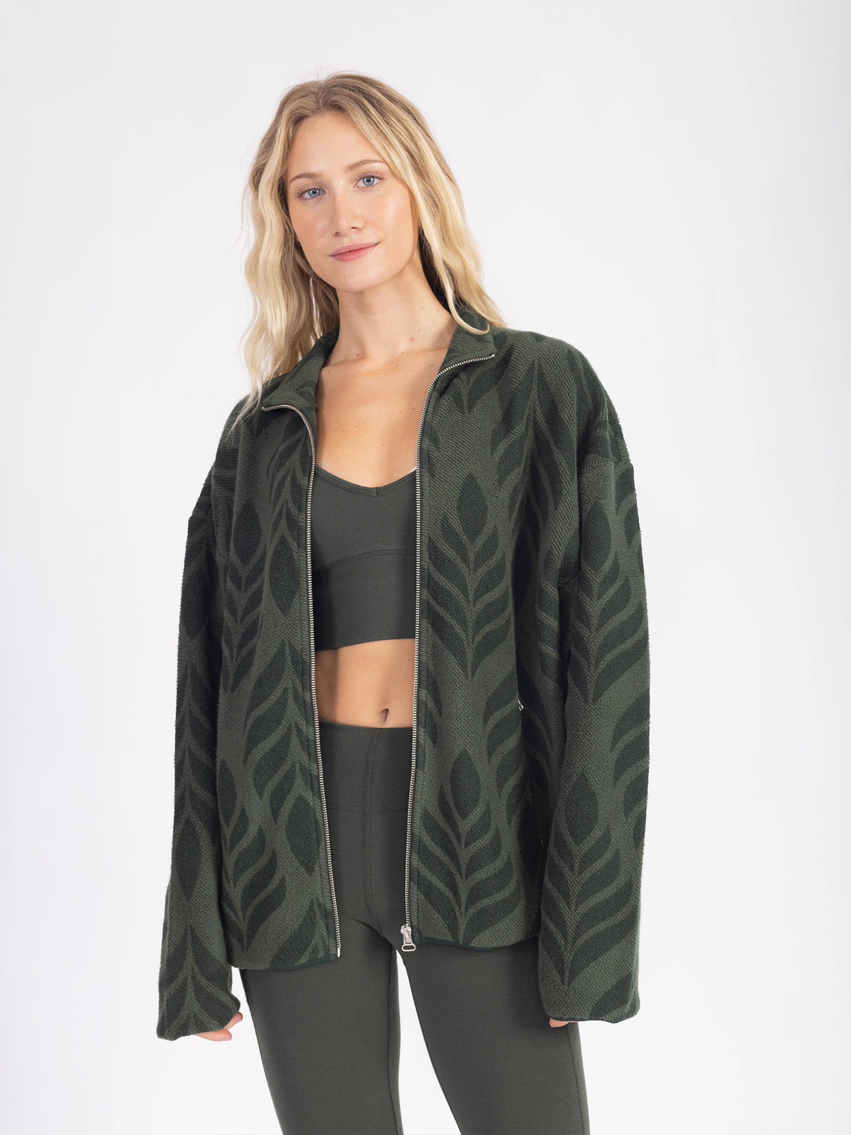 Model wearing the forest green Verdant organic cotton sherpa jacket open, full front view