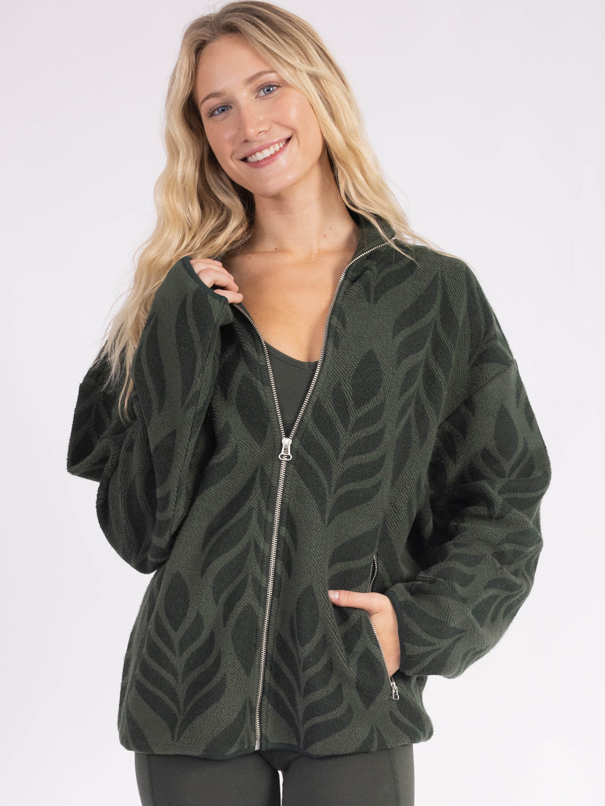Model wearing the forest green Verdant organic cotton sherpa jacket, hand in pocket