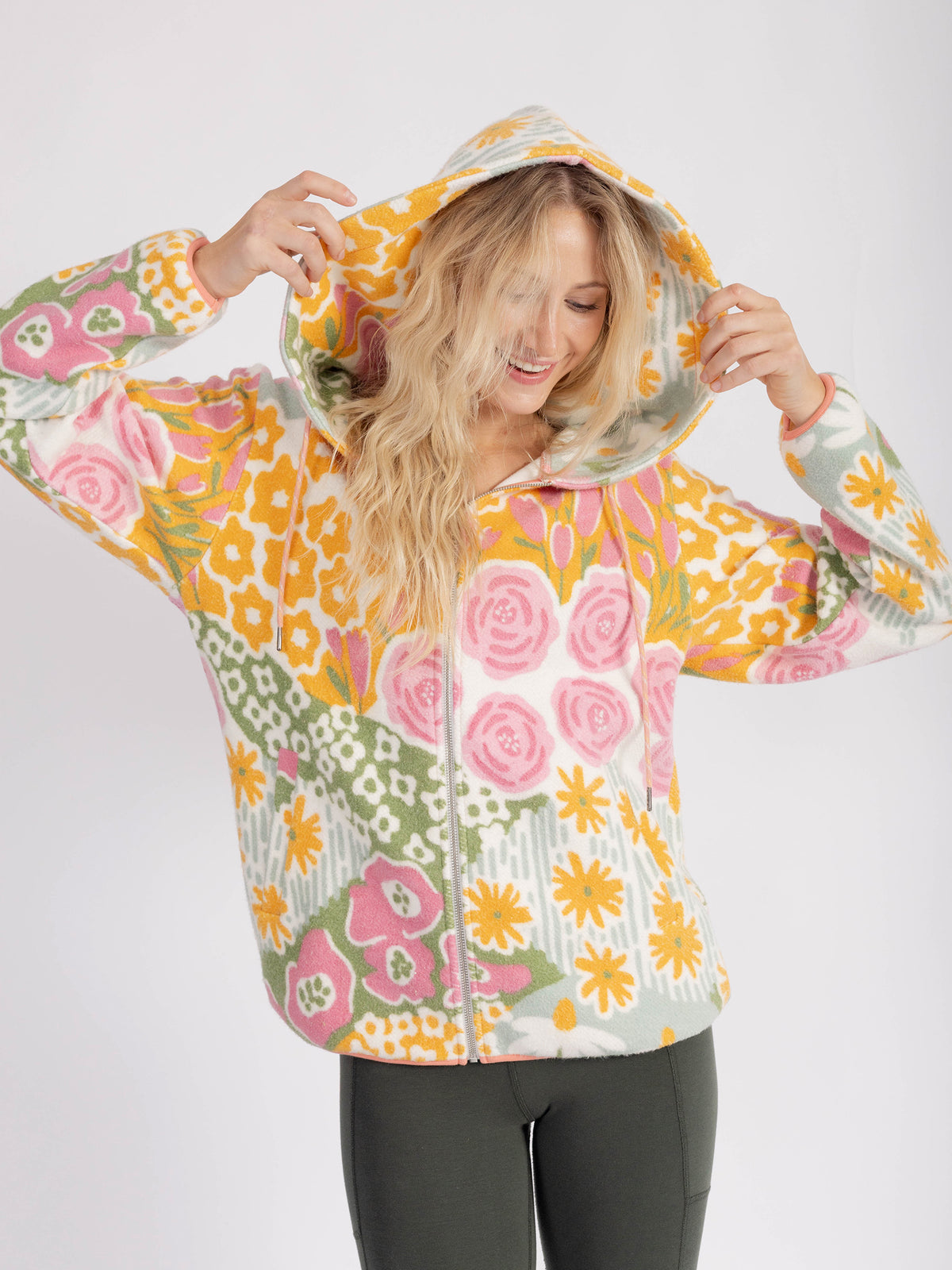 Model pulling up the hood of the floral Bouquet organic cotton sherpa zip hoodie